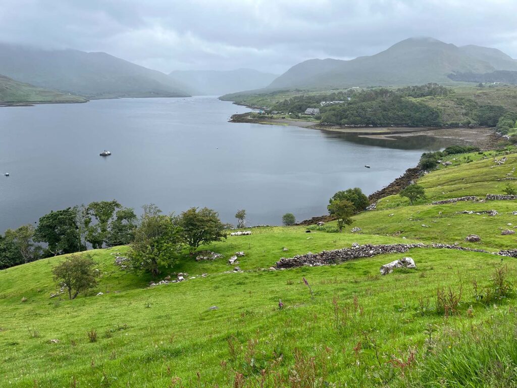 View across Killary Fjord with green hill in foreground and hills in the background