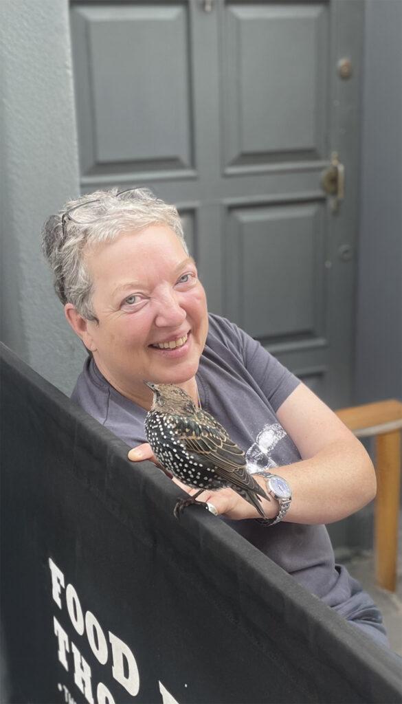 Angela with a bird in the foreground.