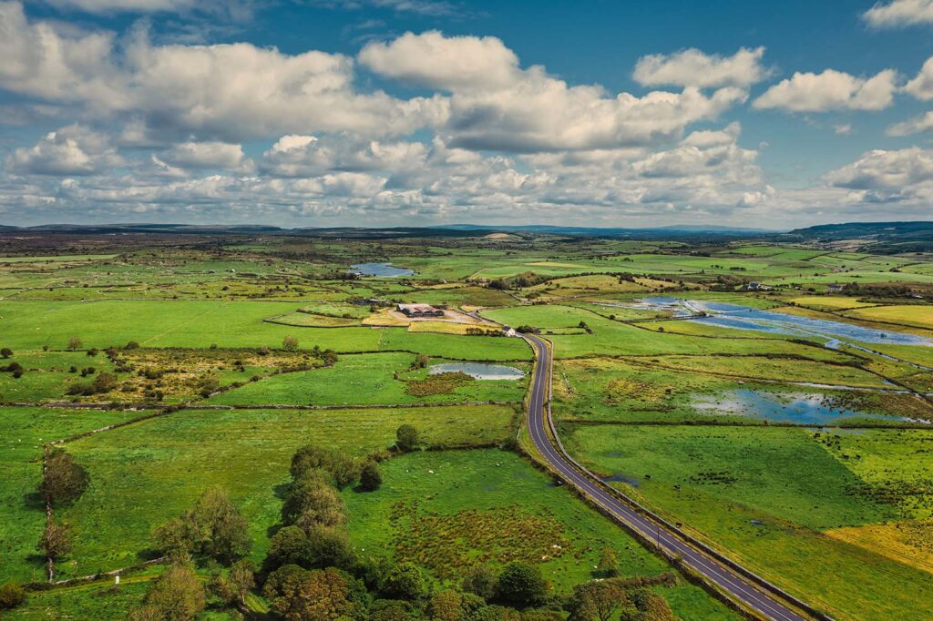 Aerial view of a road winding through farmland.
