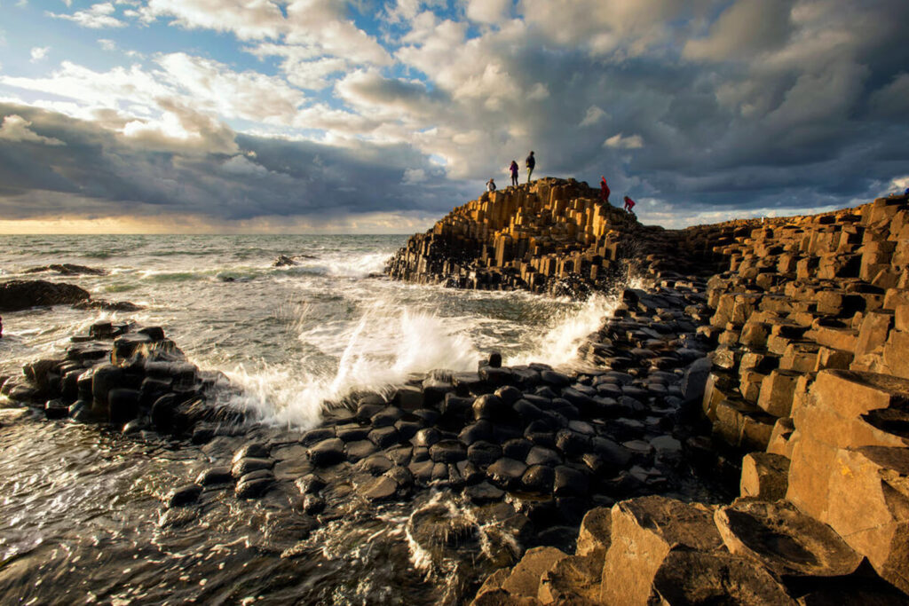 Giants Causeway with breaking wave and dramatic clouds