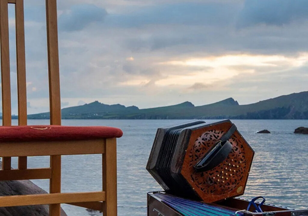 Close-up of a chair and accordion with Galway bay in the background